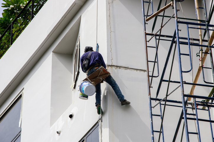 Asian Painter hanging by rope for fixing and painting exterior